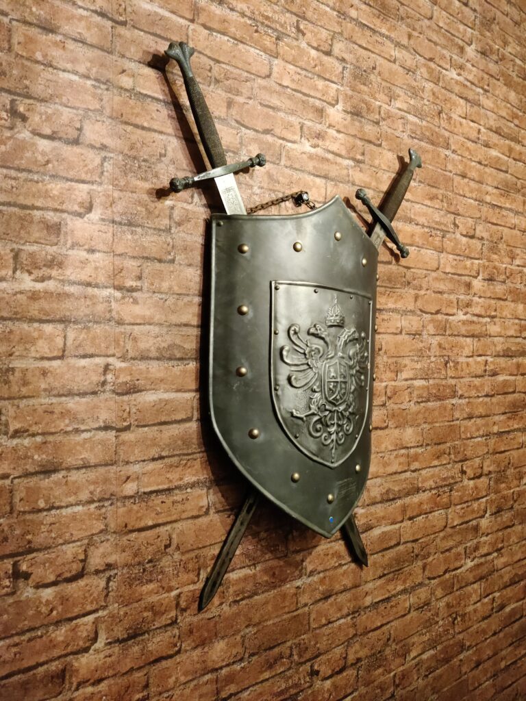 un bouclier ainsi que deux épées accrochés au mur