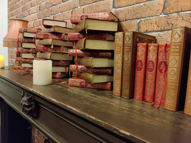 des tas de livres et des bougies sur une cheminée